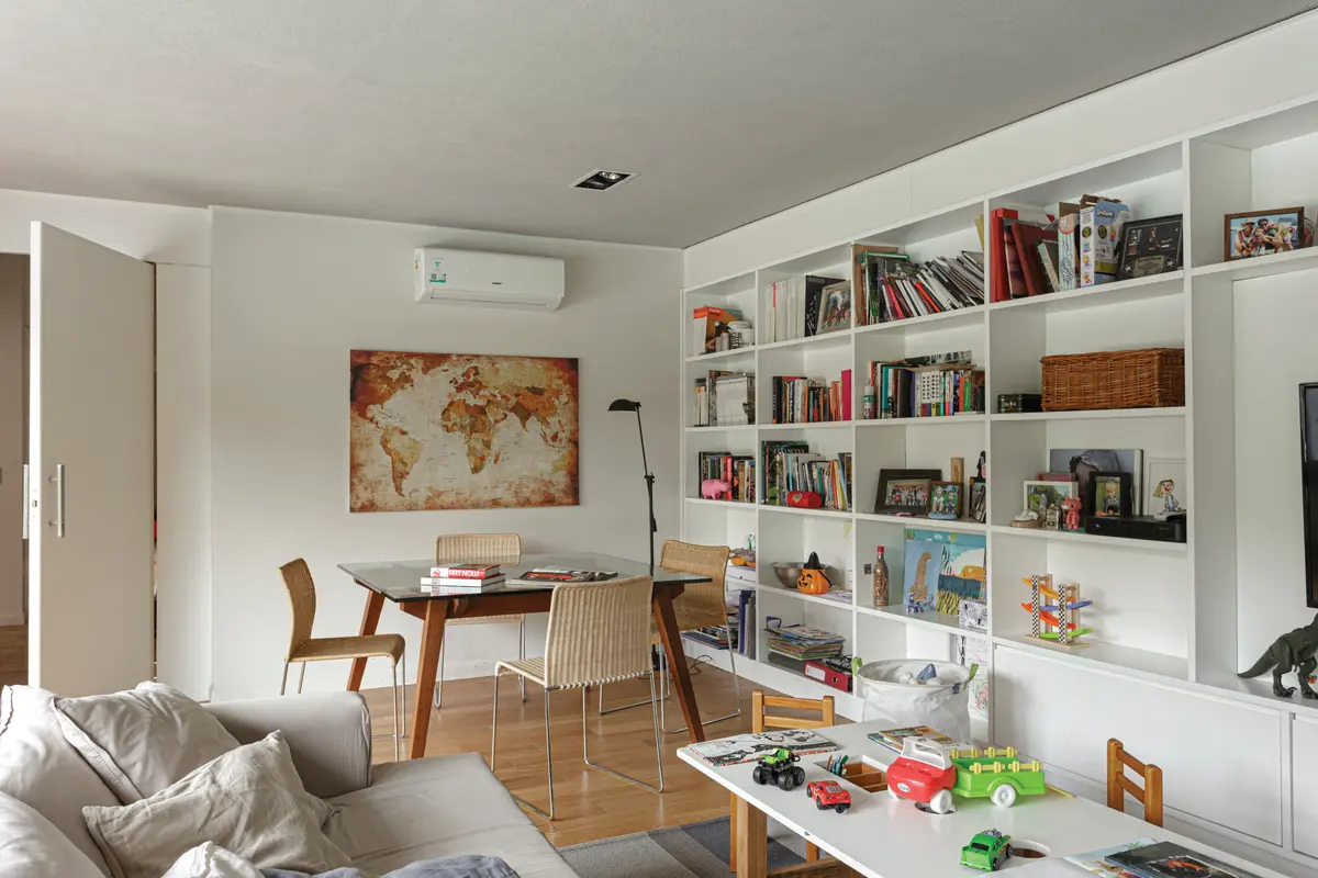 Sala de estar moderna com estantes embutidas e mapa mundi — projeto Casa Bosque Chico, por Mazzinghi Sanchez, em Garin